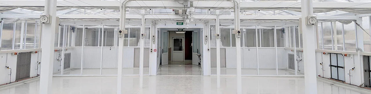 Bright white industrial quarantine and research facility with clear partitions and exit doors